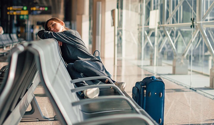 Frau mit Jetlag am Flughafen Frau mit Jetlag am Flughafen